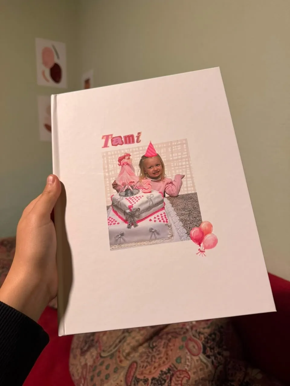 Tapa ilustrada de un fotolibro blanco: una nena de tres años soplando la velita de su torta